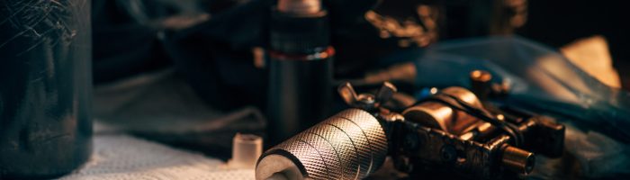 close up view of tattoo machine, ink and other equipment for tattooing process